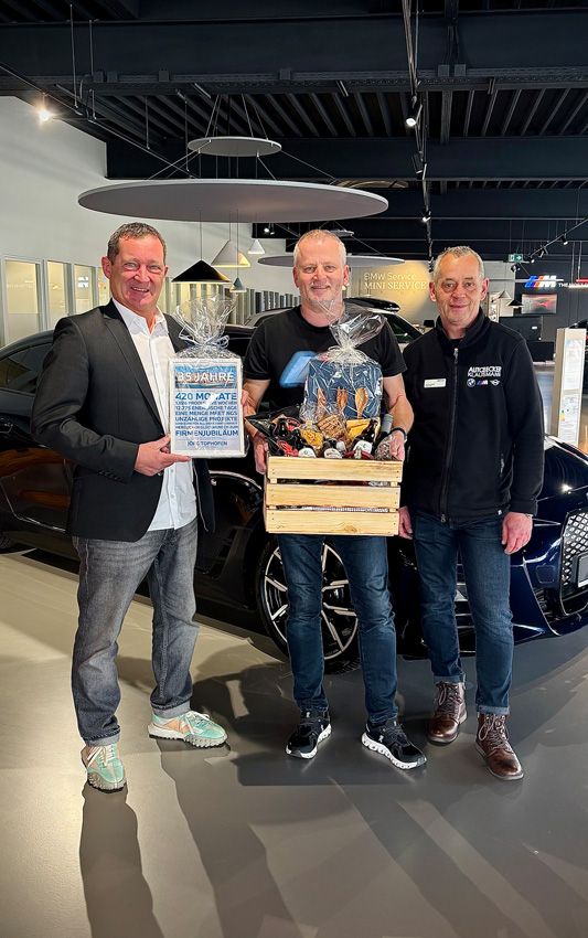 Jan Klausmann und Thomas Sobik gratulieren Jörg Tophofen zu 35 Jahren bei Auto Becker Klausmann